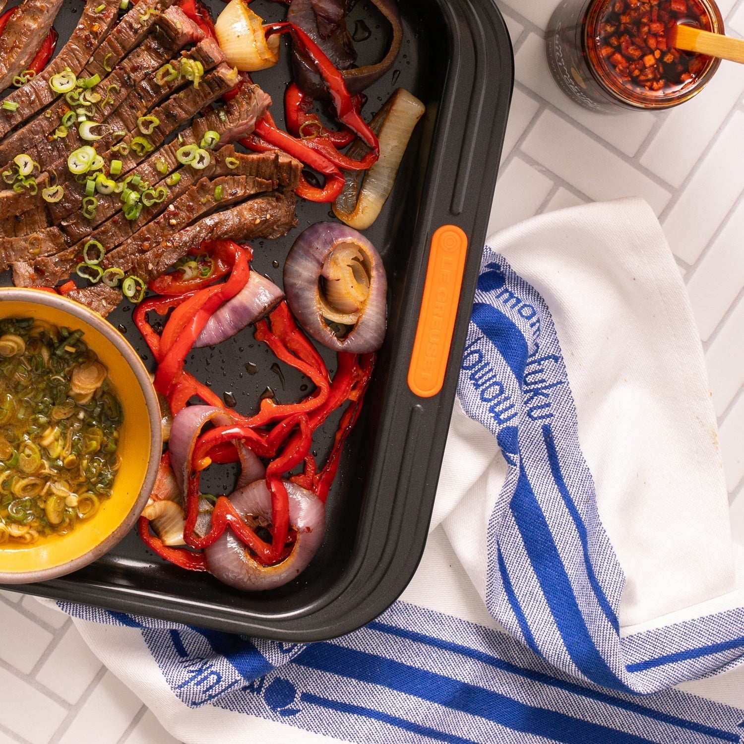 sheet pan with skirt steak and kitchen towel